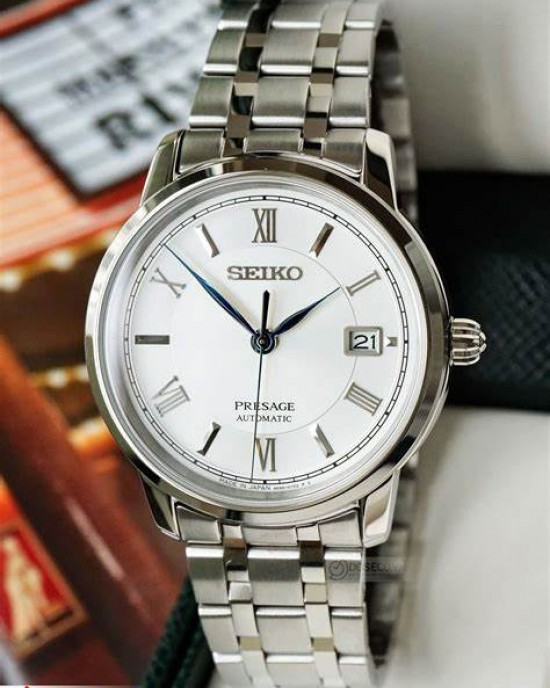 SEIKO HORLOGE PRESAGE AUTOMAAT STALEN BAND EN KAST, WITTET BLAUWE PLAAT MET ROMEINSE CIJFERS EN DATUM EN SAFFIERGLAS 100M - 79383 - SRPC05J1